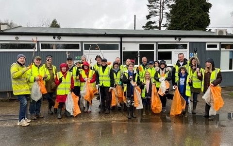 Litter pickers stand with their bags and litter picking sticks at the ready